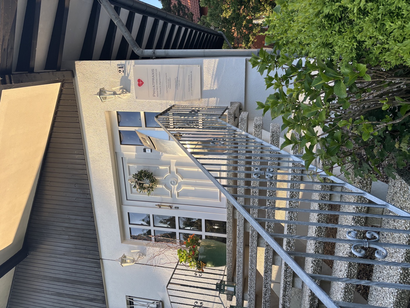 Haus der Praxis mit Eingang und Treppe